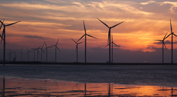 Coast sunset with silhouette of wind turbines