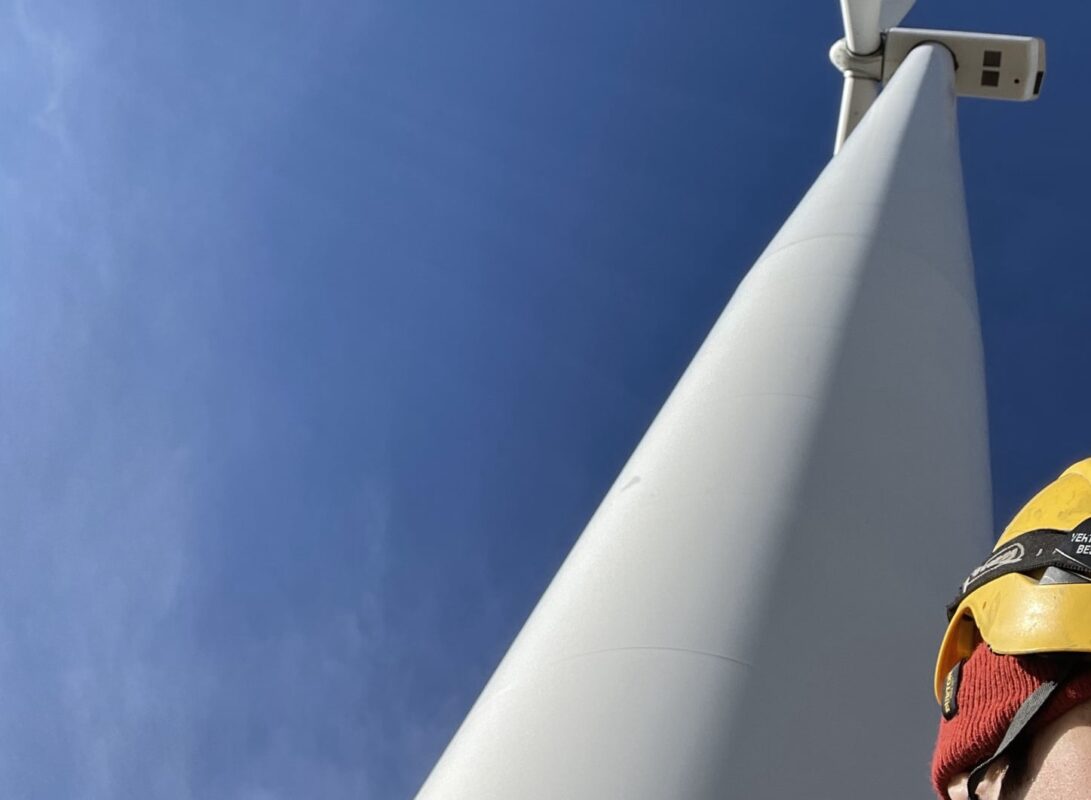 Wind turbine technician looking at wind turbine